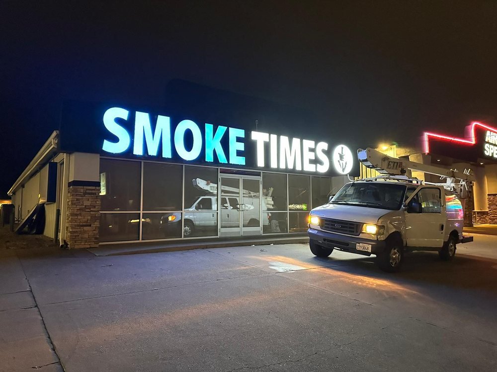 Smoke Times illuminated channel letters lit at night